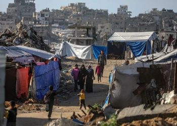 Palestinos desplazados internamente caminan entre las ruinas de edificios residenciales destruidos en el barrio de Al-Sheikh Radwan, al este de la ciudad de Gaza (Franja de Gaza).