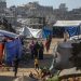 Palestinos desplazados internamente caminan entre las ruinas de edificios residenciales destruidos en el barrio de Al-Sheikh Radwan, al este de la ciudad de Gaza (Franja de Gaza).